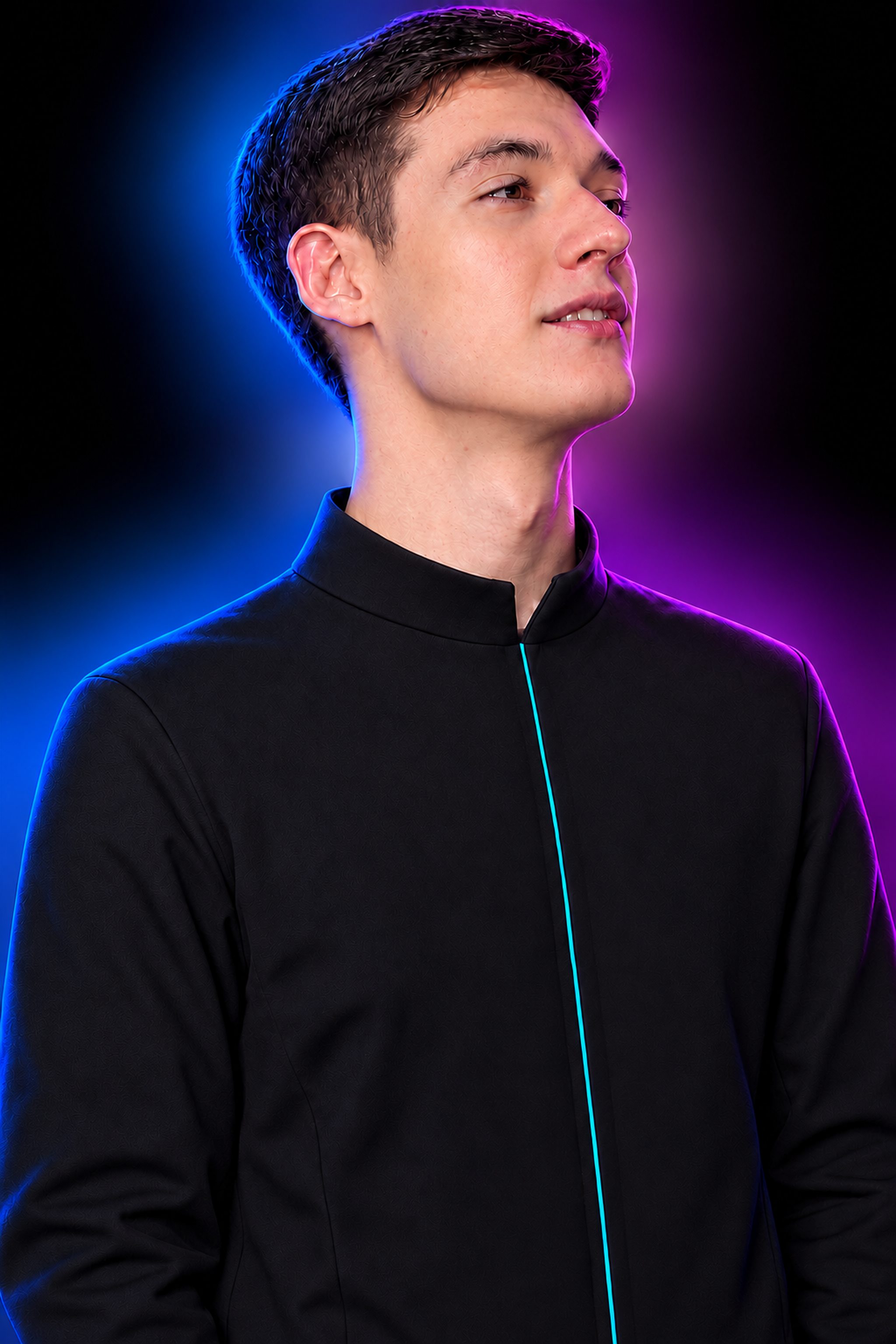 Mike looking upward, in a dark jacket with subtle blue and violet lighting